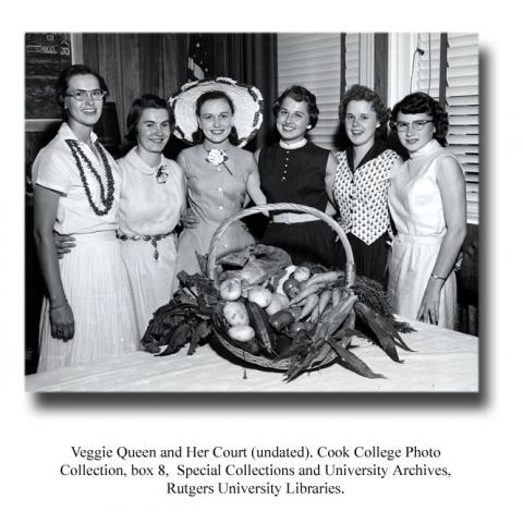 Group of women smiling while standing behind basket overflowing with vegetables. Veggie Queen and Her Court, undated. Cook College Photograph Collection, box 8. Special Collections and University Archives, Rutgers University Libraries.