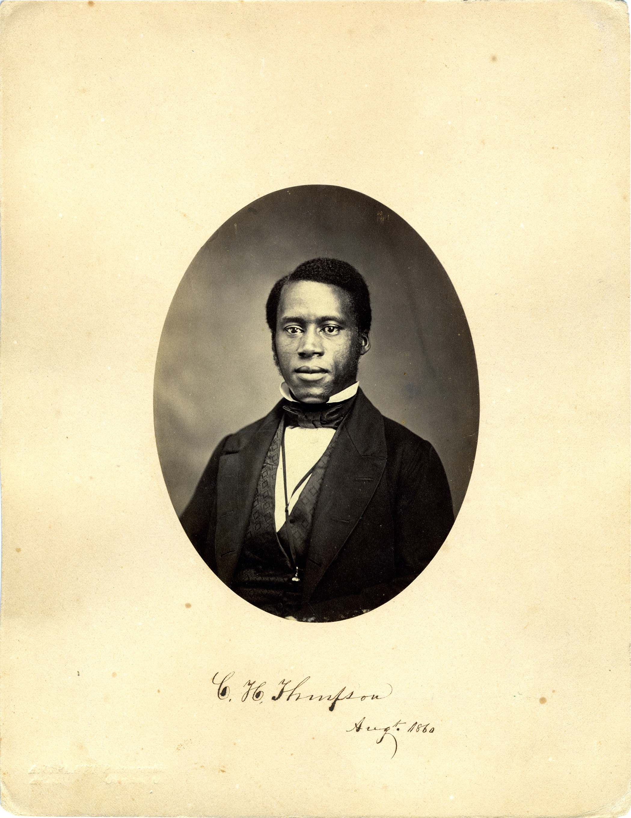 Charles H. Thompson depicted in dashing black and photo in a suit with a high collar, vest, eye loupe